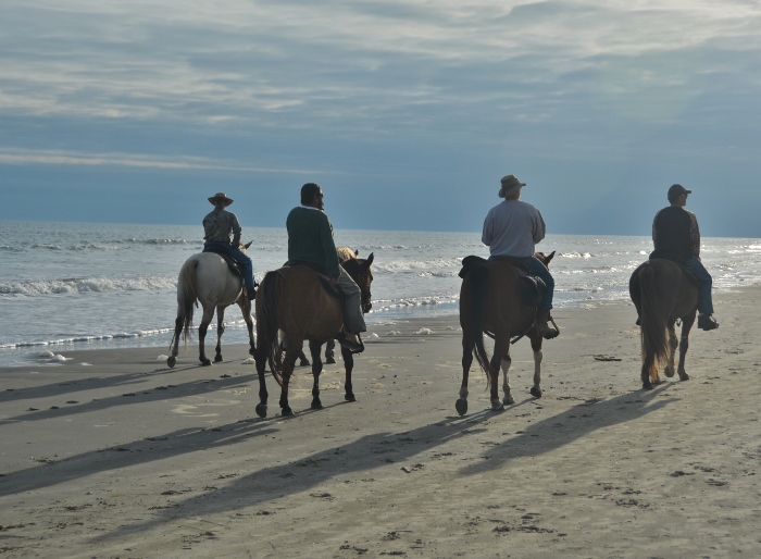 Horsemen riding on Galveston west beach
